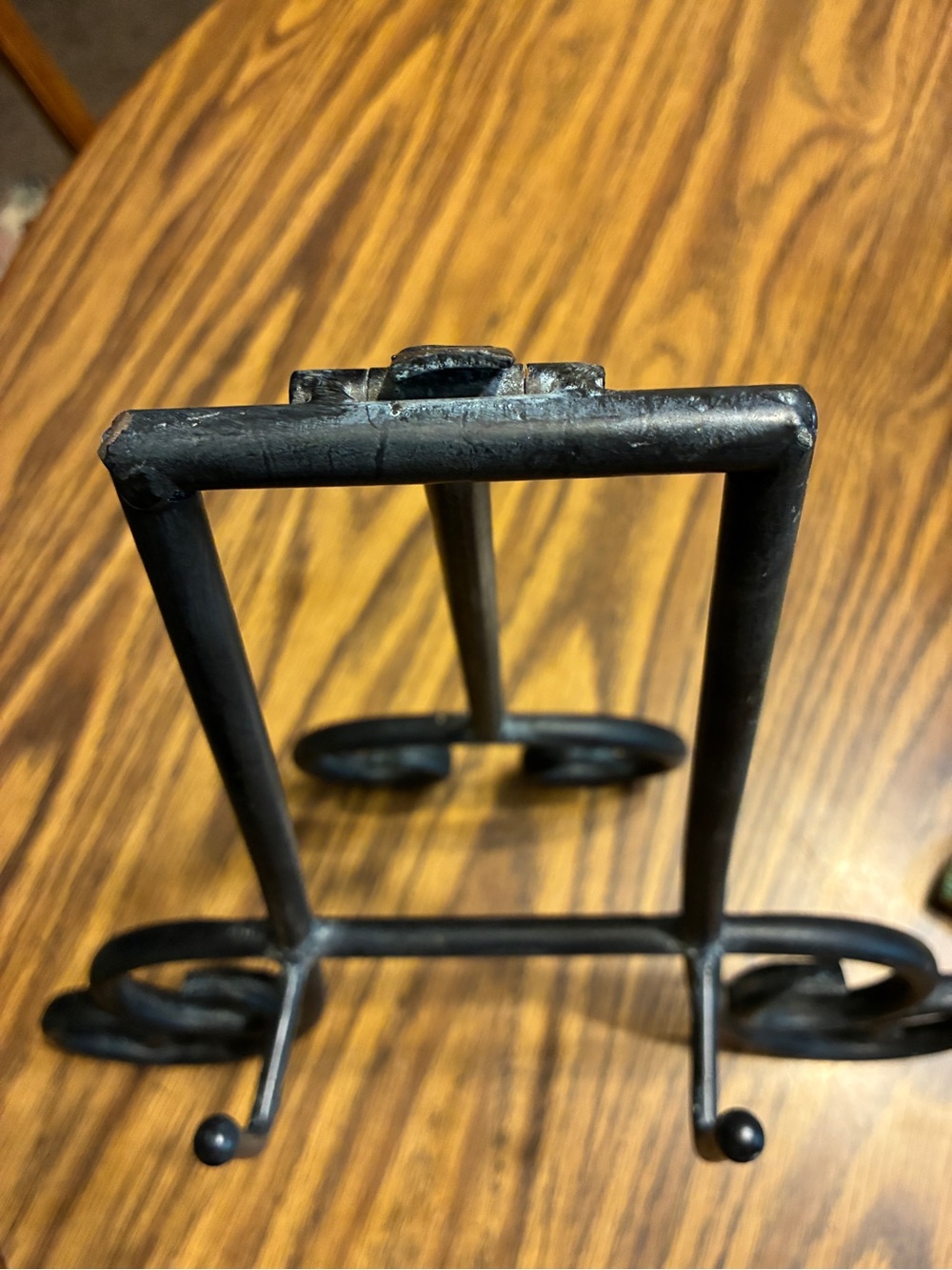 black metal table top easel features an intricate scroll work design - Picture 5 of 6